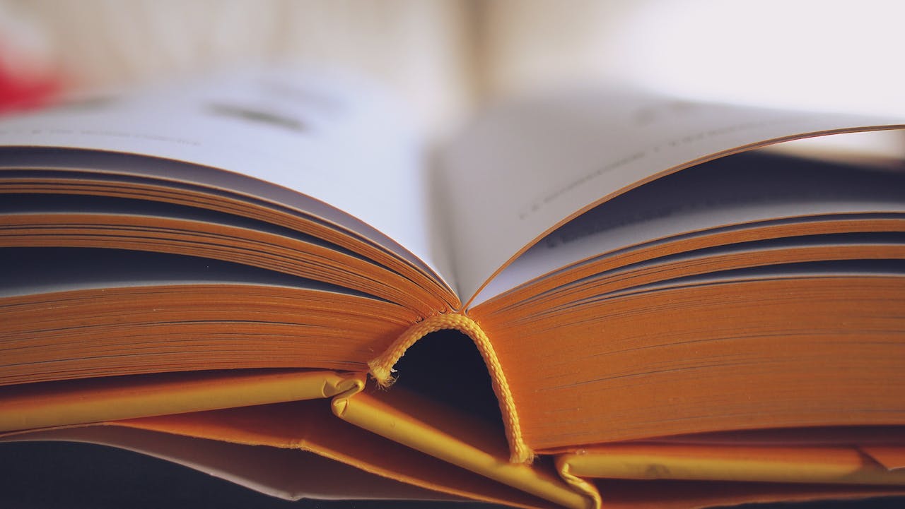 Detailed close-up of an open book with yellow pages, emphasizing learning and knowledge.